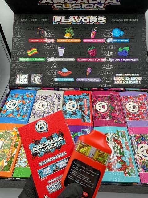 Open Arcadia Fusion display with dual-flavor devices, colorful retail boxes, and ten flavor pairings