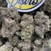 Close-up of Grape Cream Cake Exotics with dense purple-green cannabis buds, orange pistils and frosty trichomes