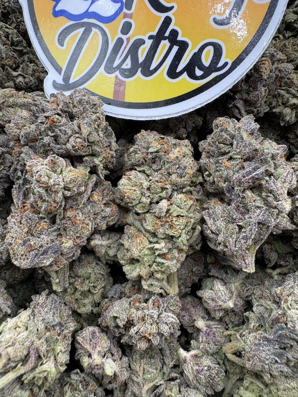 Close-up of Grape Cream Cake Exotics with dense purple-green cannabis buds, orange pistils and frosty trichomes Close-up of Grape Cream Cake Exotics with dense purple-green cannabis buds, orange pistils and frosty trichomes