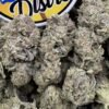 Frosty purple and green Glitter Bomb cannabis flower buds beside the LA Kings Distro logo