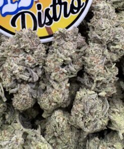 Frosty purple and green Glitter Bomb cannabis flower buds beside the LA Kings Distro logo
