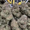 Frosty purple and green Project 4516 cannabis flower buds beside the LA Kings Distro logo