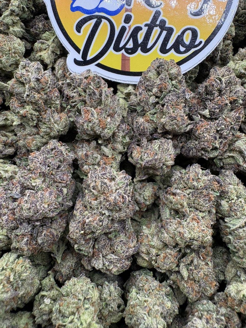 Frosty purple and green Z Runtz cannabis flower buds with bright orange pistils Frosty purple and green Z Runtz cannabis flower buds with bright orange pistils