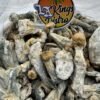 Dried mushrooms presented as Penis Envy with thick stems, compact caps, blue bruising, and an LA Kings Distro sign
