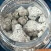 Open jar of Kaws Rocks Snowcaps coated flower beside blue Snowcap Edition packaging