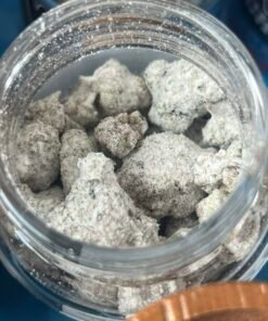Open jar of Kaws Rocks Snowcaps coated flower beside blue Snowcap Edition packaging