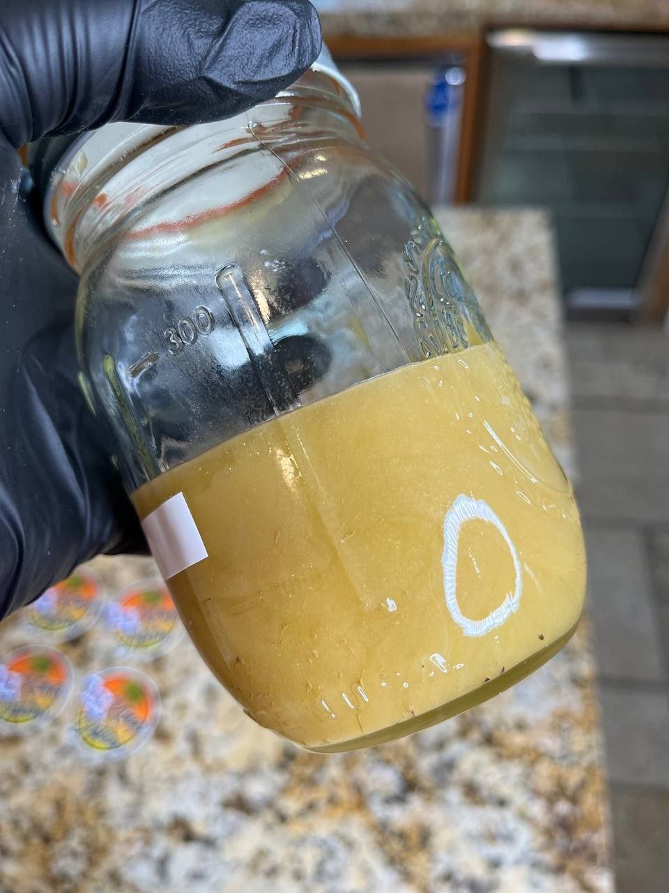 Glass jars labeled 224 Badder containing golden Cat 3 cannabis concentrate Glass jars labeled 224 Badder containing golden Cat 3 cannabis concentrate