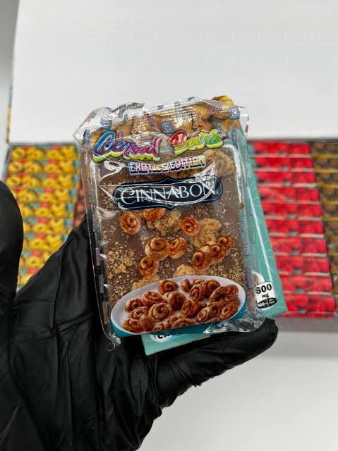 Cinnabon-themed Cereal Bars 600MG cannabis-infused chocolate bar held in a gloved hand Cinnabon-themed Cereal Bars 600MG cannabis-infused chocolate bar held in a gloved hand
