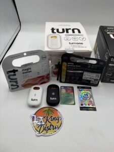 Turn One 2G disposable cannabis vape in black with Botanica Blends Magic Melon and White Gummy Bear packaging