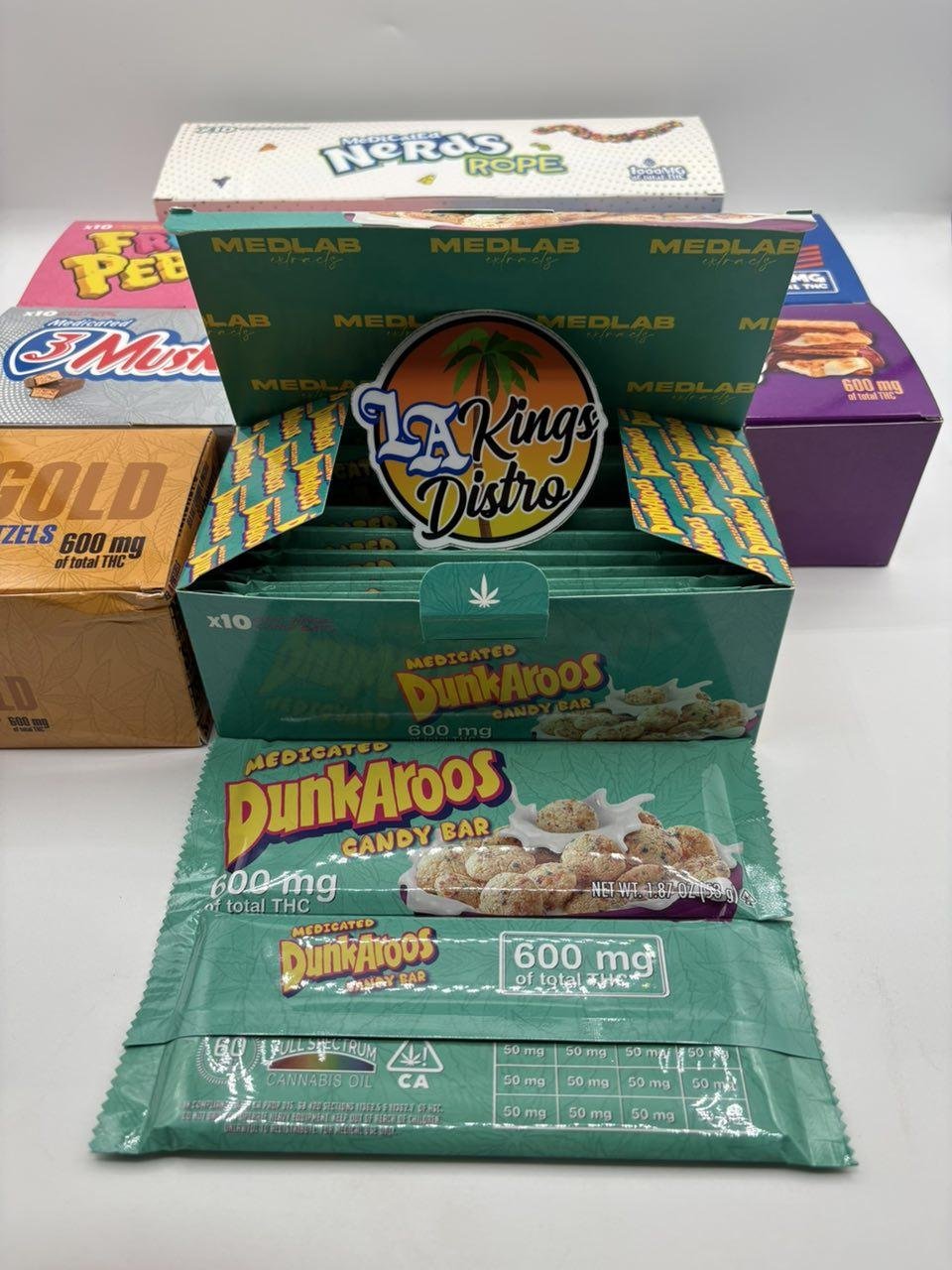 MedLabs DunkAroos 600mg chocolate bar packaging displayed with assorted edible boxes and Nerds Rope MedLabs DunkAroos 600mg chocolate bar packaging displayed with assorted edible boxes and Nerds Rope